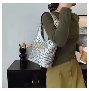 Detail view of silver punk style hobo bag with metallic round stud embellishments