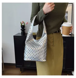 Fashionable silver punk-style bucket bag with round studs shown in a lifestyle view