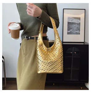 Elegant lifestyle shot of a women's gold hobo bag featuring punk style round metal studs