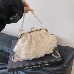 Gros plan d'un sac sous le bras élégant en dentelle blanche avec perles et sangle
