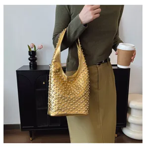 Close-up of a stylish gold punk style hobo bag with round stud embellishments for women