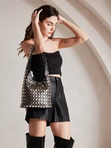 Detailed view of a punk-style black bucket bag featuring heavy silver rivet embellishments
