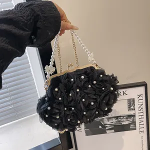 Gros plan sur un élégant sac de soirée noir avec fleurs et perles décoratives