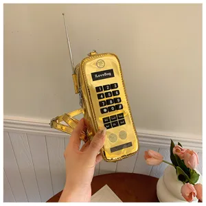 Close-up of golden brick phone-shaped novelty handbag with tactile keypad