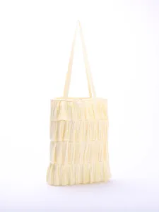 Close-up detail of light yellow multi-layered pleated ruffle tote bag with thin straps