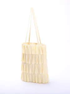 Detailed close-up of a light cream pleated ruffle shoulder tote bag showing layered texture