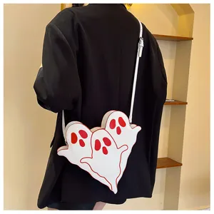 Detail view of a cute white Halloween ghost crossbody bag worn over a black blazer jacket