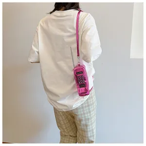Detailed back view of a creative pink vintage cell phone shaped crossbody bag on model
