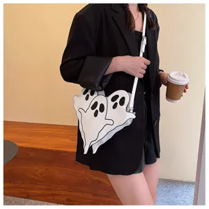 Close-up of a unique white ghost trio shaped crossbody bag paired with a stylish black blazer.
