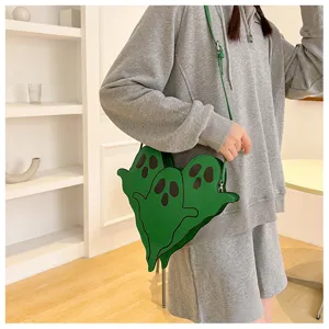 Close-up of a green ghost-shaped crossbody bag worn by a model in a minimalist room