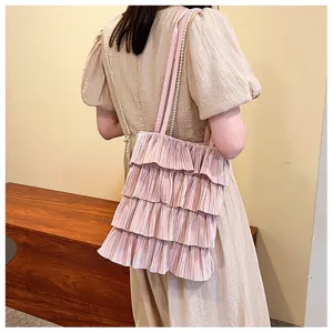 Detail einer rosa plissierten Rüschen-Tote-Bag mit Perlenriemen für Damen.