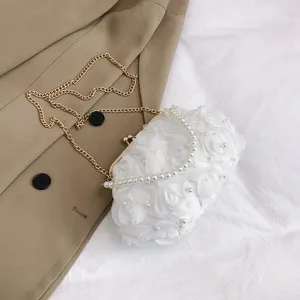 Détail d'un sac de soirée floral blanc élégant avec poignée en perles et chaîne