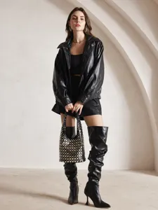 Punk style black bucket bag with silver studs held by a model in leather outfit