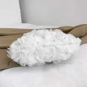 Gros plan sur un sac sous l'aisselle blanc avec fleurs en tissu et perles