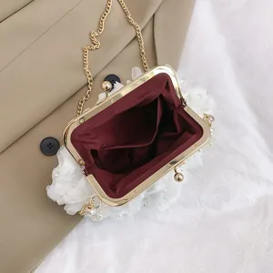 Vue intérieure d'une élégante pochette florale blanche avec perles et cadre doré