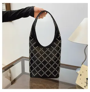 Detailed view of punk style black bucket bag with silver rivet diamond pattern