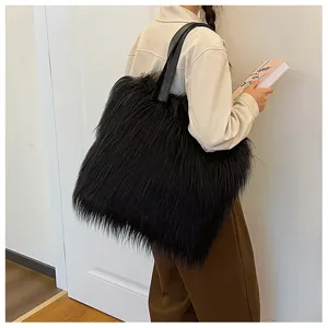Detailed side view of a large black faux fur tote bag carried by a model with a book