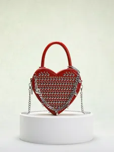 Red heart-shaped studded crossbody bag with metallic chain detail and stylish design.