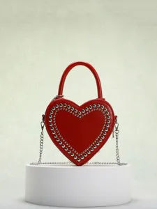 Red heart-shaped crossbody bag with silver studs and chain strap, stylish trendy detail view.