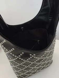 Detail view of a punk style black bucket bag with silver rivet diamond pattern.