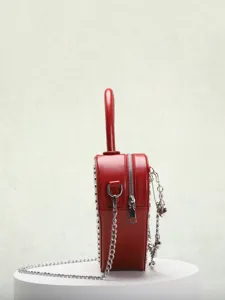 Red heart shaped handbag detail, metal chain strap, rivet decor, elegant crossbody bag showcase
