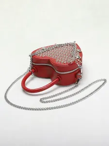 Red heart-shaped studded shoulder bag detail, stylish metal chain strap and top handle design.