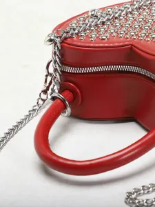 Red heart-shaped handbag detail showcasing metallic chain and smooth leather texture.