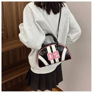 Fashionable black and white striped bowling bag with pink number patch shown on a model