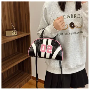 Model wearing a black and white striped bowling bag with pink 02 patch and trim.