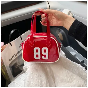 Close-up detail of a trendy red glossy bowling handbag featuring a bold white 89 number print