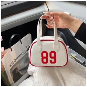 Close-up of white patent leather bowling bag with red '89' print and piping details.
