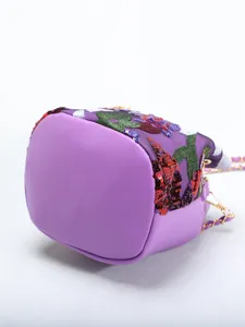 Detailed macro shot of the purple leather bottom and floral sequin embroidery on this bucket bag