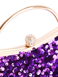 Detailansicht der lila Pailletten und des goldenen Strassverschlusses einer Abendtasche