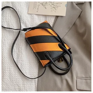Detail of small bucket bag with black and orange diagonal stripes in PU leather texture.
