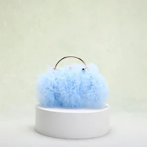 Dettaglio ravvicinato di borsa da sera in tulle azzurro arricciato con manico circolare