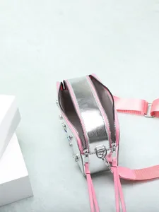 Bolso de cámara plateado con correa rosa, pedrería de colores y doble cremallera.