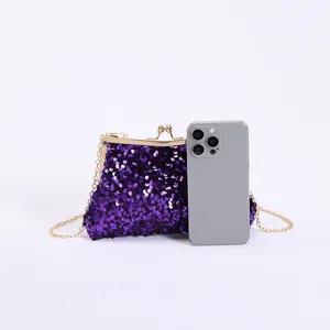 Detaillierter Größenvergleich einer lila Pailletten-Abendtasche neben einem Smartphone