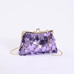 Detailaufnahme der lila Pailletten einer Abendtasche mit goldenem Kettenriemen