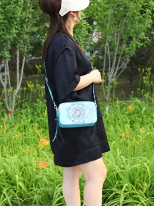 Close-up lifestyle detail of a blue vintage mandala print crossbody camera bag for women