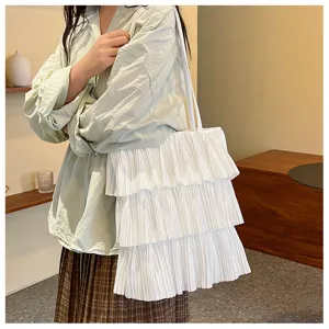 Weiße plissierte Rüschen-Tragetasche am Modell mit minimalistischem Dekor