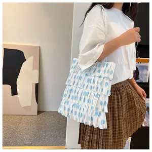 Detail einer weißen gefalteten Tragetasche mit blauen Punkten im Cake-Skirt-Stil