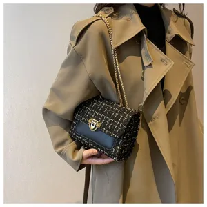 Elegant black and gold tweed chain flap bag held by a model wearing a classic trench coat