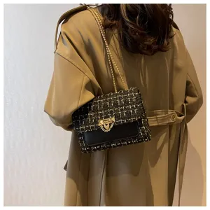 Close-up detail of a classic tweed plaid chain shoulder bag paired with a stylish khaki trench coat