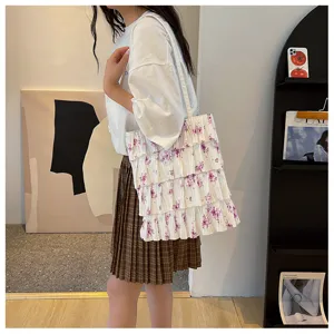 Detailansicht der plissierten Stofftasche mit filigranem violettem Blumenmuster.