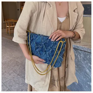 Detailansicht der blauen gewaschenen Denim Stepp Schultertasche mit goldener Kette.