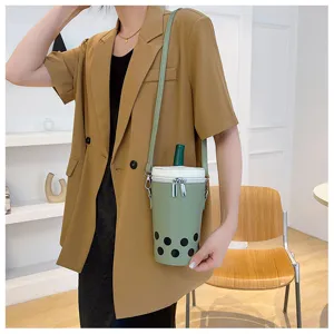 Detailed view of a unique sage green bubble tea shaped crossbody bag worn by a model
