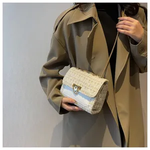Detail view of an elegant tweed lattice chain crossbody bag with a gold-tone metal lock.