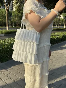 Detail einer weißen gerafften Tragetasche mit mehrlagigem Stufendesign für Damen