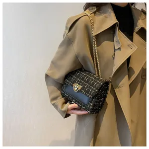 Elegant black and white tweed check chain shoulder bag detail worn with khaki trench coat
