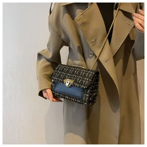 Detailed view of a black tweed plaid crossbody bag with an elegant gold chain strap